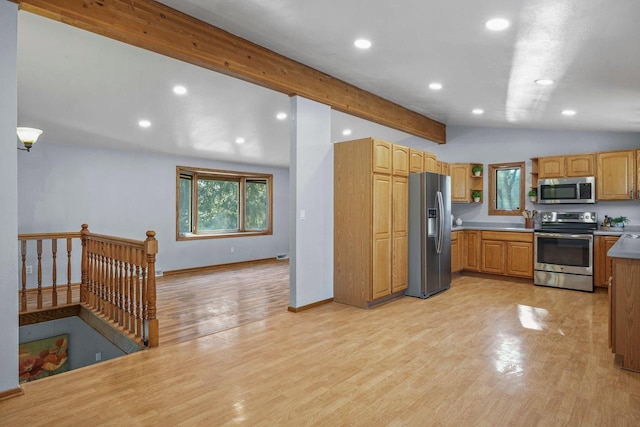 kitchen featuring vaulted ceiling with beams, light hardwood / wood-style floors, and appliances with stainless steel finishes