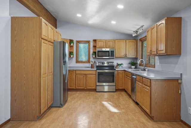 kitchen with lofted ceiling, sink, light hardwood / wood-style flooring, and appliances with stainless steel finishes