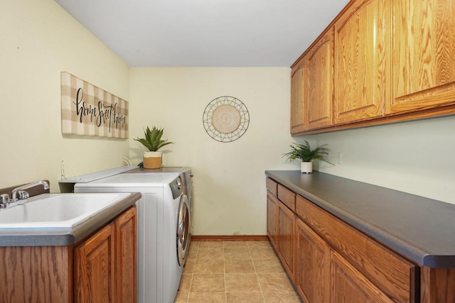 washroom featuring cabinets, sink, washer and dryer, and light tile patterned floors