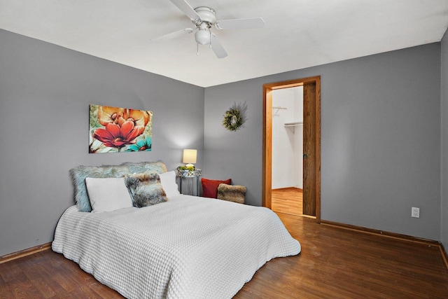 bedroom featuring hardwood / wood-style floors, a spacious closet, and ceiling fan