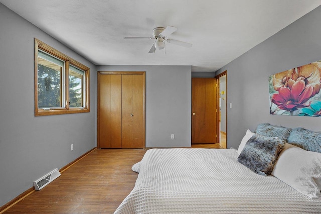 bedroom with ceiling fan, light hardwood / wood-style floors, and a closet