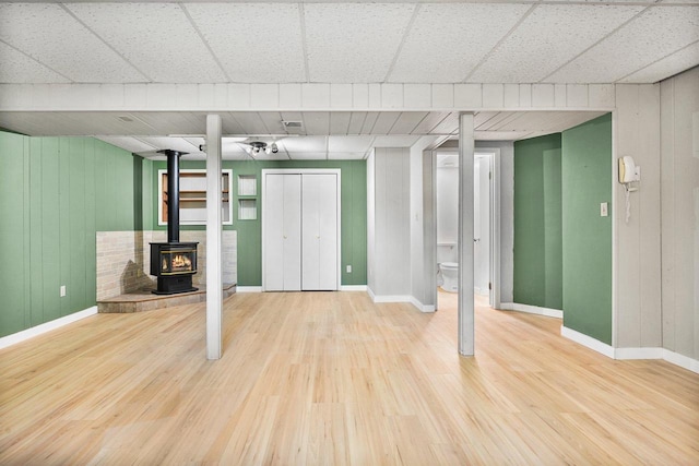 basement featuring hardwood / wood-style flooring and a wood stove