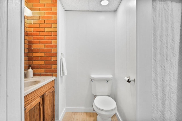 bathroom with vanity, wood-type flooring, toilet, and a paneled ceiling