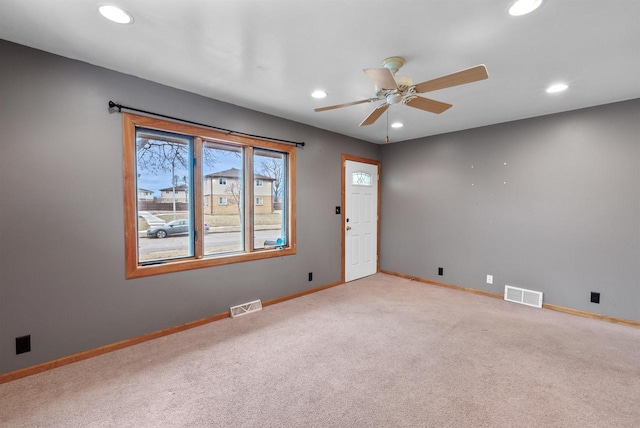 spare room featuring ceiling fan and light colored carpet