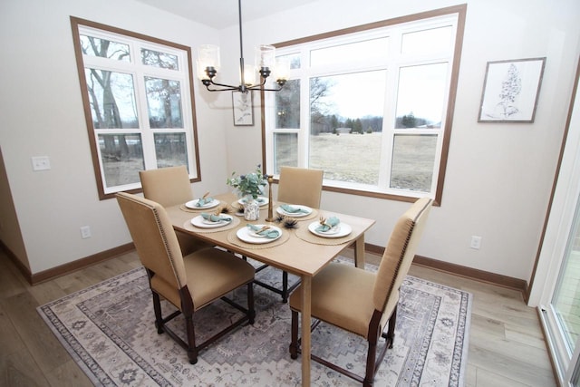 dining area featuring light wood-type flooring and a notable chandelier