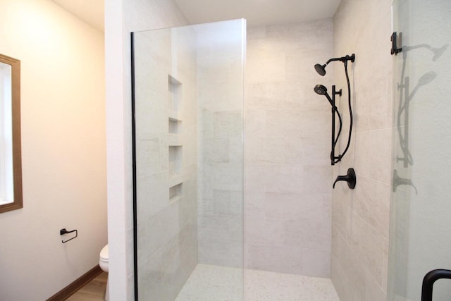 bathroom with toilet and a shower with shower door