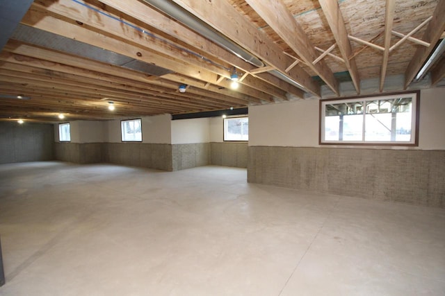 basement featuring brick wall and plenty of natural light