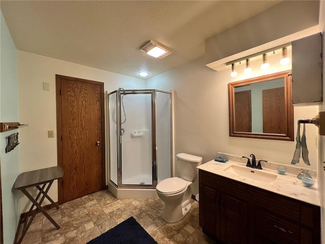 bathroom with a textured ceiling, toilet, a shower with door, and vanity