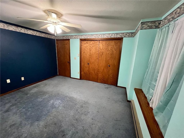 unfurnished bedroom with ceiling fan, a baseboard heating unit, and carpet flooring