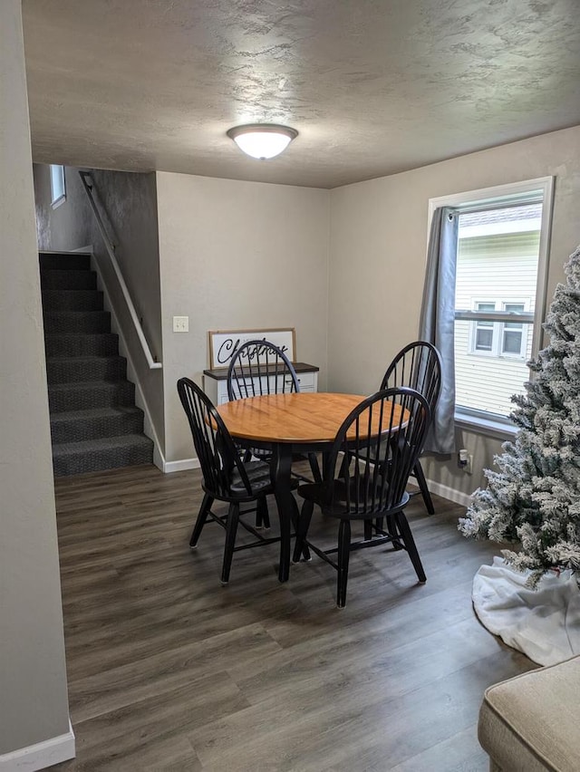 dining room with dark hardwood / wood-style flooring and a textured ceiling