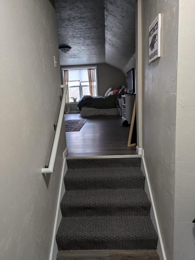 stairs featuring hardwood / wood-style floors and a textured ceiling