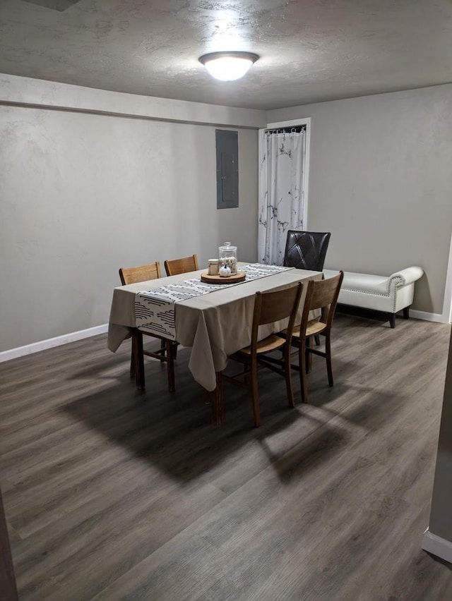 dining room featuring a textured ceiling, electric panel, and dark hardwood / wood-style flooring