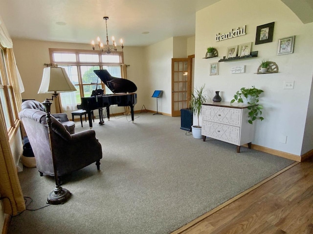 sitting room with carpet and an inviting chandelier