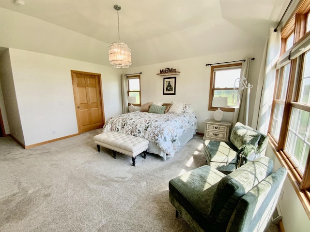 carpeted bedroom with a notable chandelier and vaulted ceiling