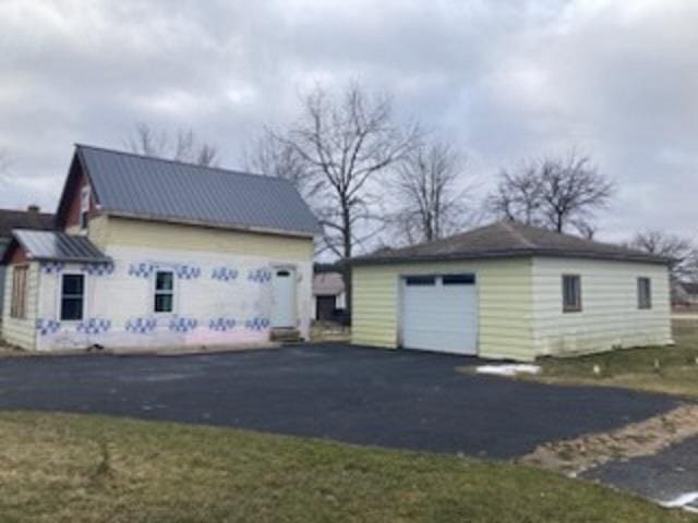 view of side of property featuring a garage and an outbuilding