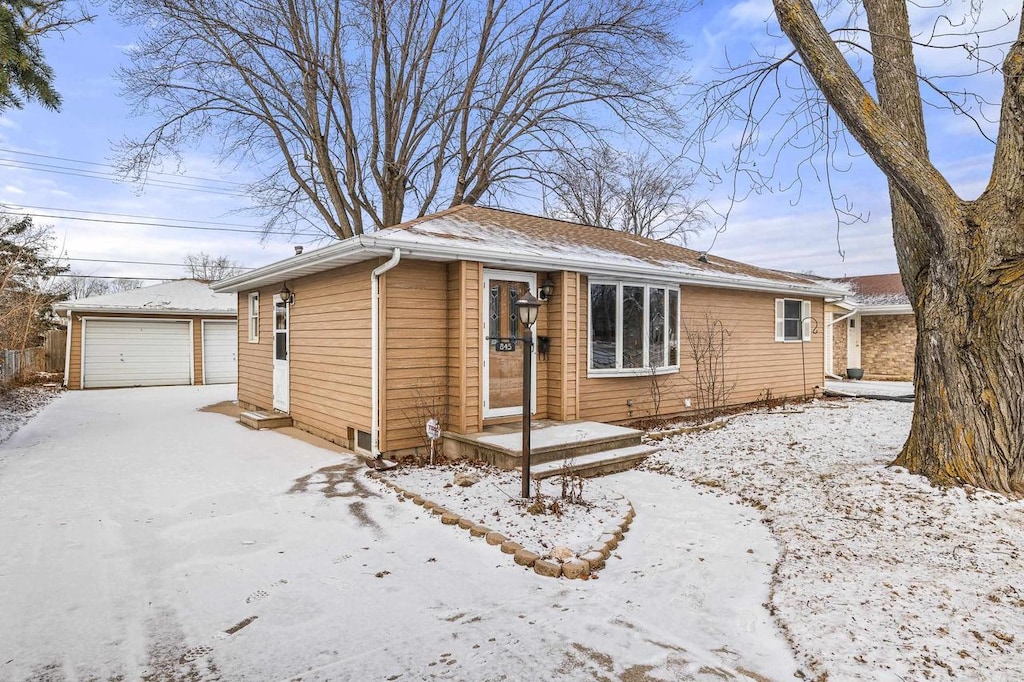 view of front of house featuring a garage and an outbuilding