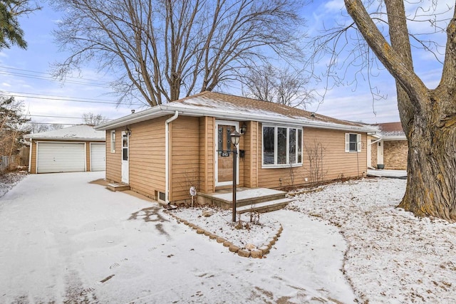 view of front of house featuring a garage and an outbuilding