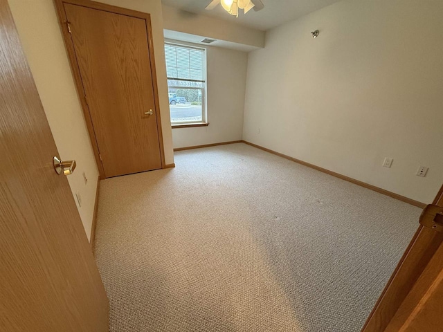 spare room featuring ceiling fan and light carpet