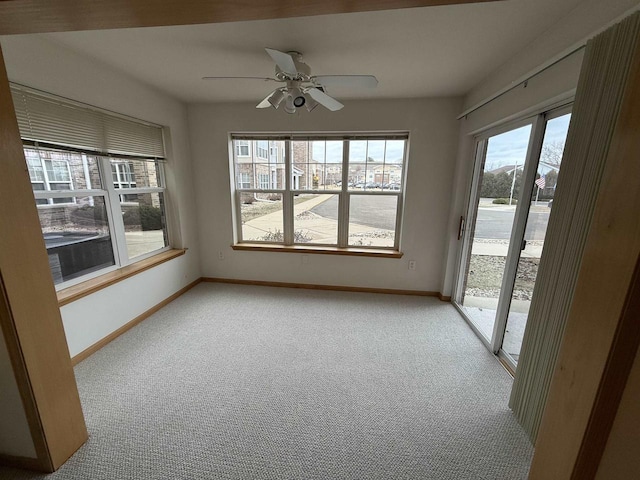 carpeted spare room featuring ceiling fan