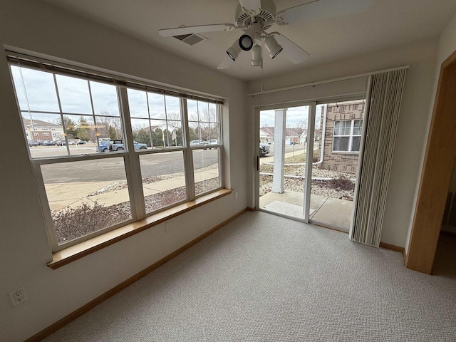 unfurnished sunroom featuring ceiling fan