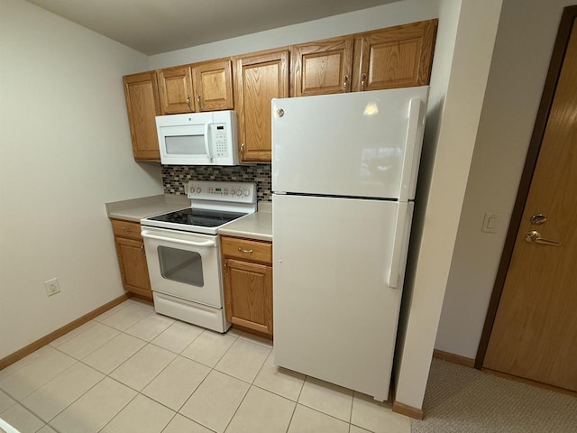 kitchen with light tile patterned floors, backsplash, and white appliances