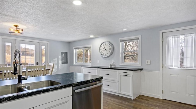 kitchen featuring sink, white cabinetry, stainless steel dishwasher, and a textured ceiling