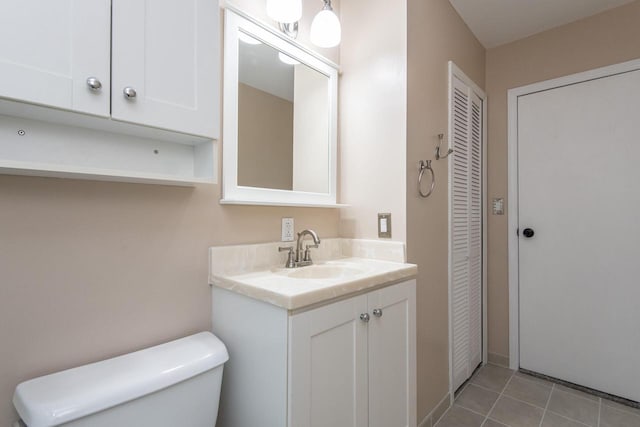 bathroom with toilet, tile patterned floors, and vanity