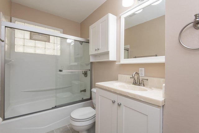 full bathroom featuring toilet, tile patterned floors, enclosed tub / shower combo, and vanity