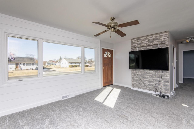 unfurnished living room with ceiling fan, a healthy amount of sunlight, and carpet floors