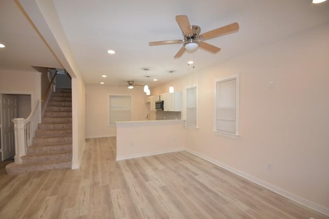 unfurnished living room with ceiling fan and light hardwood / wood-style flooring