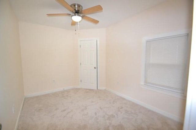 empty room featuring ceiling fan and light colored carpet