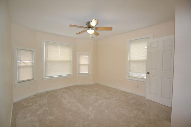 spare room with ceiling fan and light colored carpet