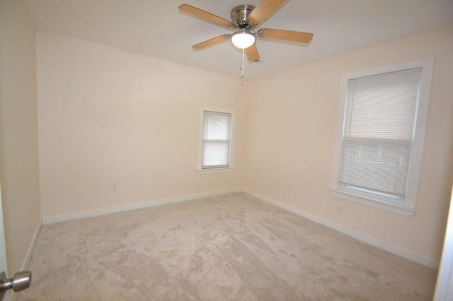 empty room featuring ceiling fan and light carpet