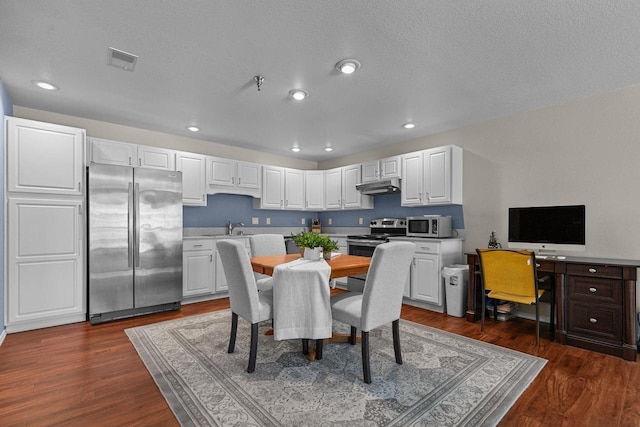 dining space featuring a textured ceiling, dark hardwood / wood-style floors, and sink