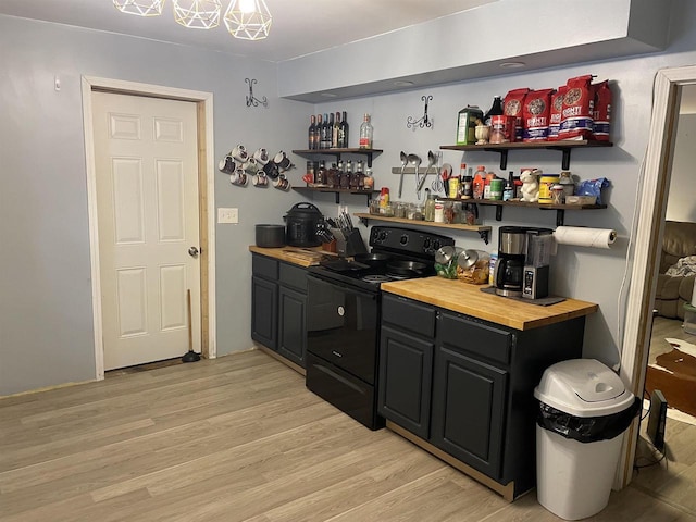 bar with butcher block countertops, black range with electric stovetop, and light hardwood / wood-style flooring