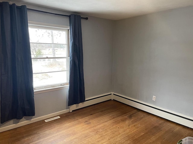 empty room with a healthy amount of sunlight, light wood-style flooring, visible vents, and baseboards