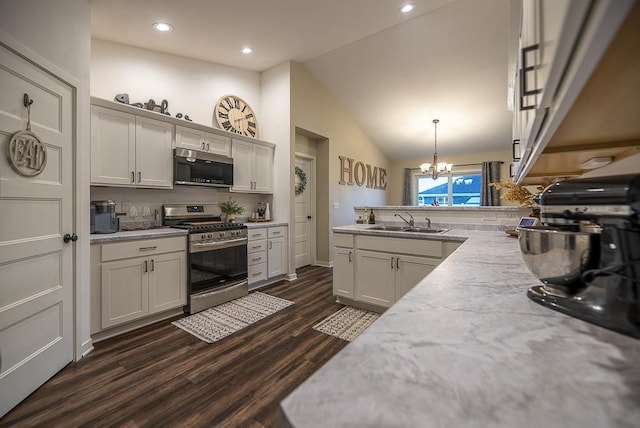 kitchen featuring a notable chandelier, pendant lighting, sink, appliances with stainless steel finishes, and dark hardwood / wood-style flooring