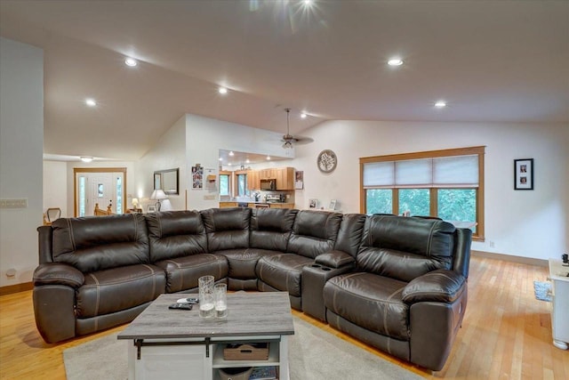 living room featuring light wood-type flooring and vaulted ceiling