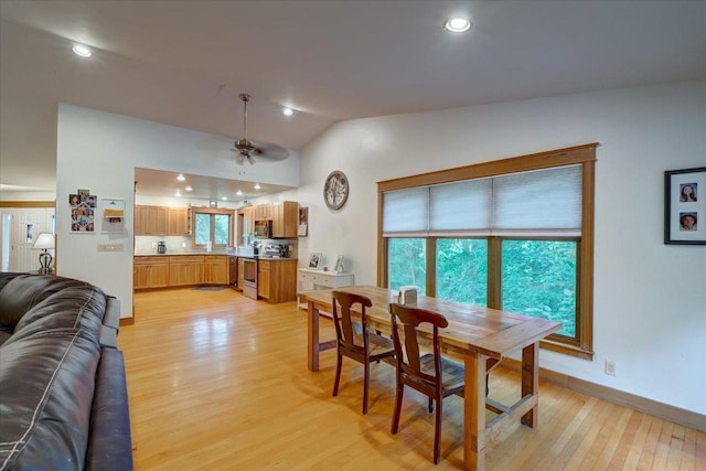 dining area featuring vaulted ceiling, ceiling fan, and light hardwood / wood-style flooring