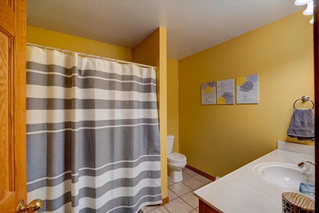 bathroom with toilet, vanity, and tile patterned flooring