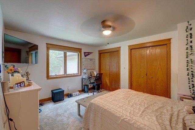 bedroom featuring carpet floors, ceiling fan, and multiple closets