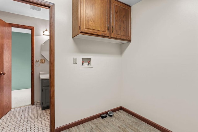 laundry area with hookup for a washing machine and cabinets