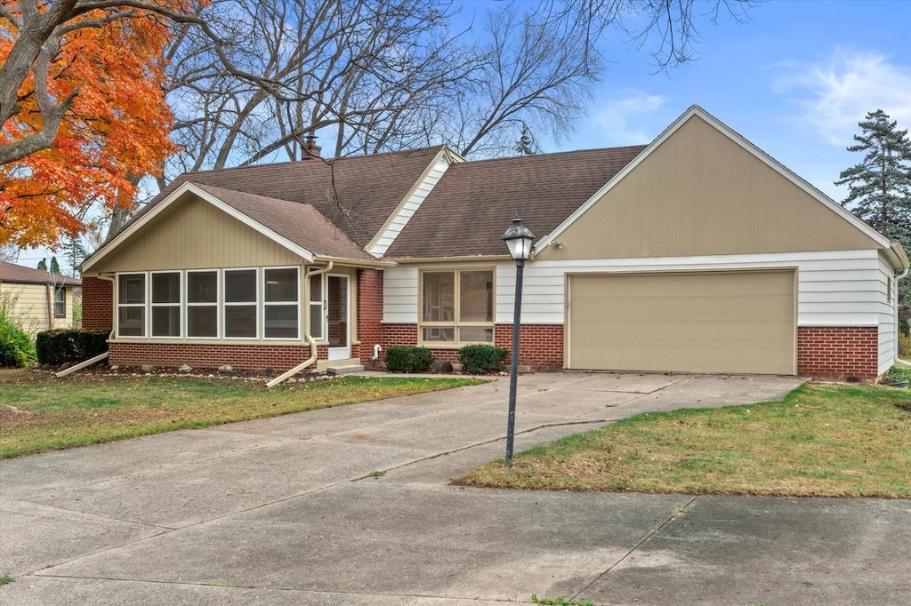 ranch-style home with a front lawn and a garage