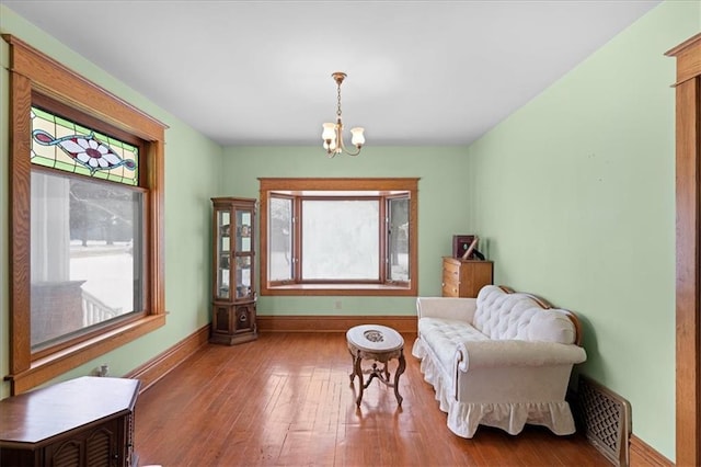 sitting room with a wealth of natural light, a chandelier, and hardwood / wood-style flooring