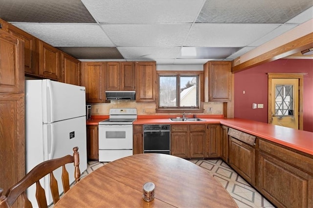 kitchen with a paneled ceiling, sink, kitchen peninsula, and white appliances