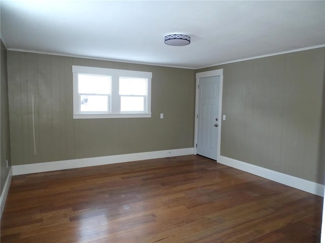 spare room featuring dark hardwood / wood-style flooring and ornamental molding