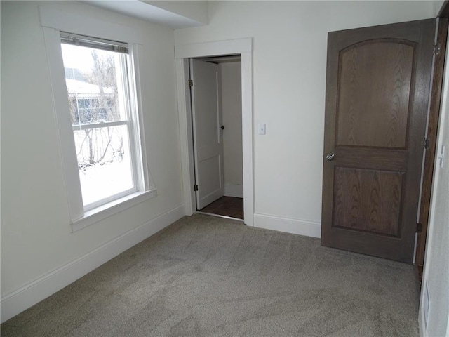 unfurnished bedroom featuring light carpet and a closet