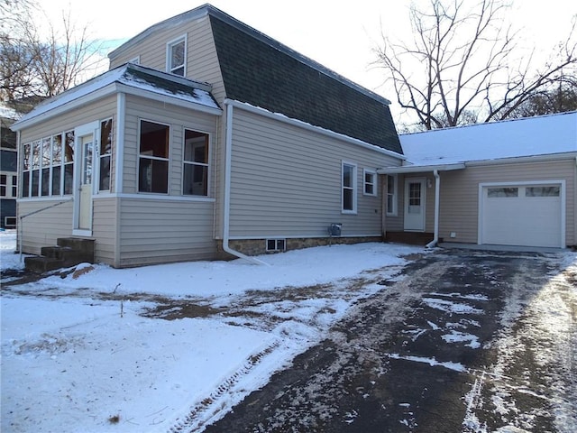 view of snow covered exterior featuring a garage