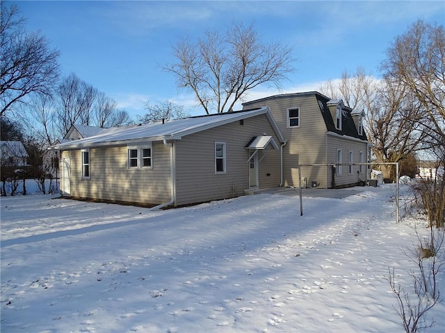 view of snow covered rear of property