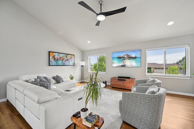 living room with ceiling fan, hardwood / wood-style floors, and vaulted ceiling